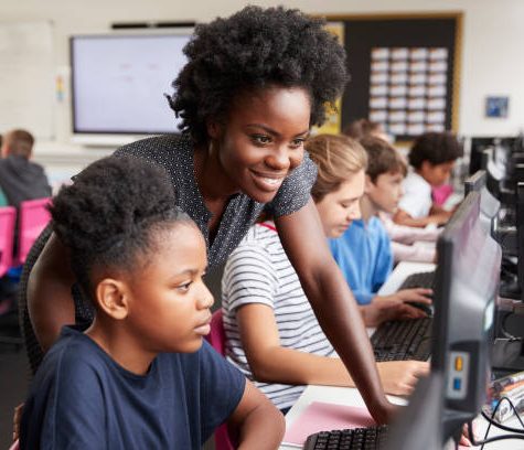 istockphoto-1047617072-612x612 Teacher Helping Female Pupil Line Of High School Students Working at Screens In Computer Class